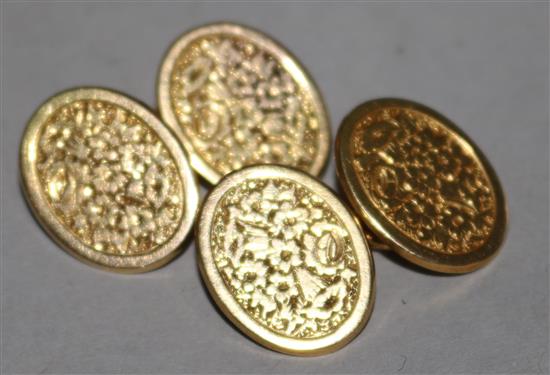 A pair of gold oval cufflinks.